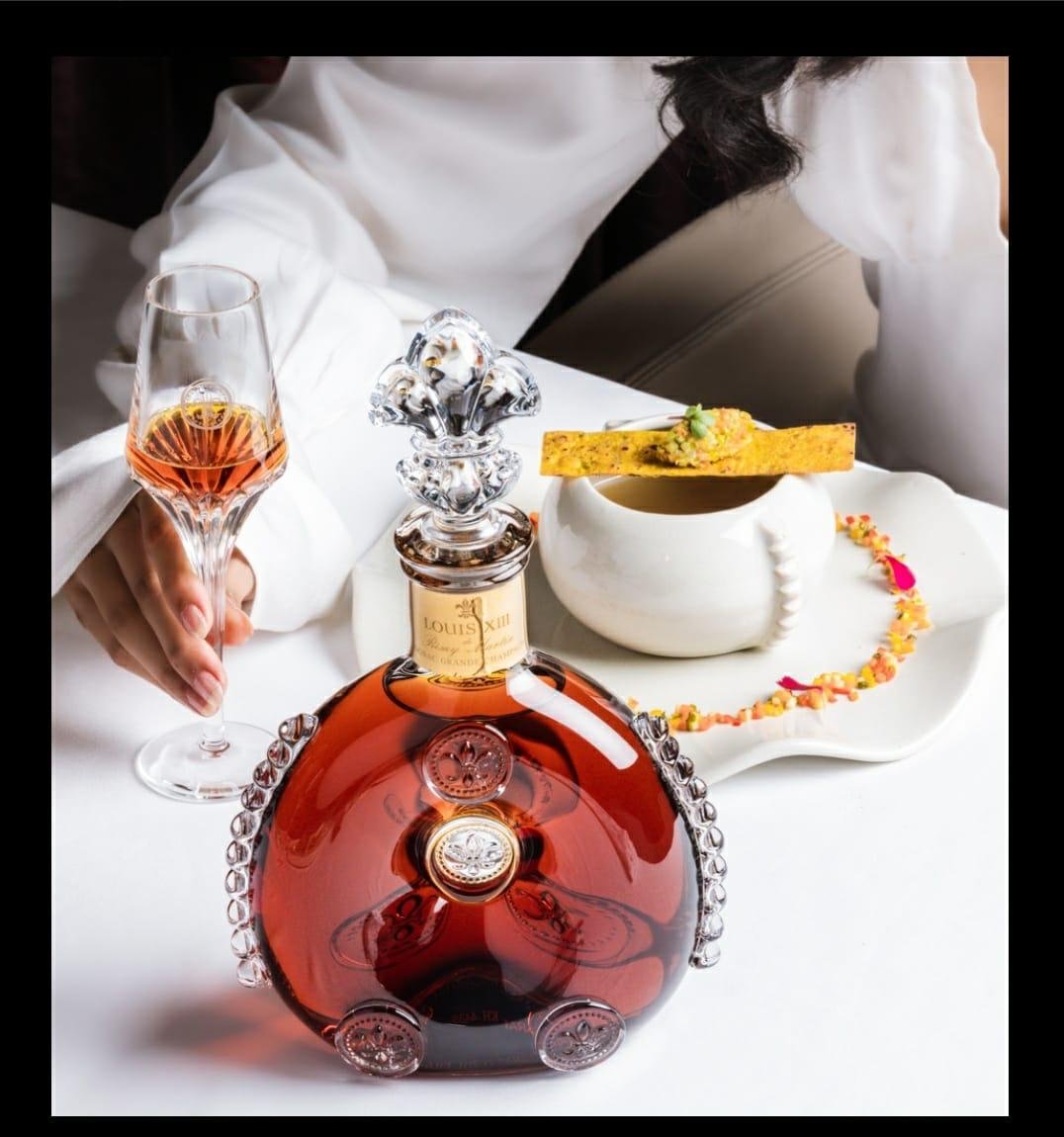 Louis XIII decanter beside a small bowl and tuile